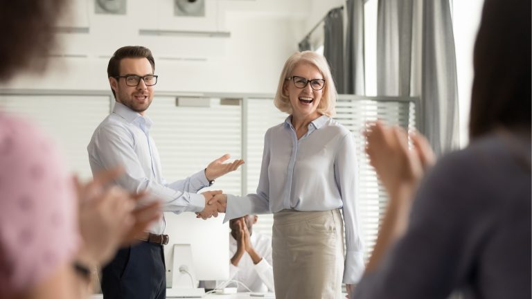 Business owner shaking hands with a satisfied customer after a successful meeting.