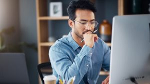 Man working on a computer to improve content for AI search and GEO.