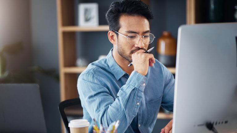 Man working on a computer to improve content for AI search and GEO.