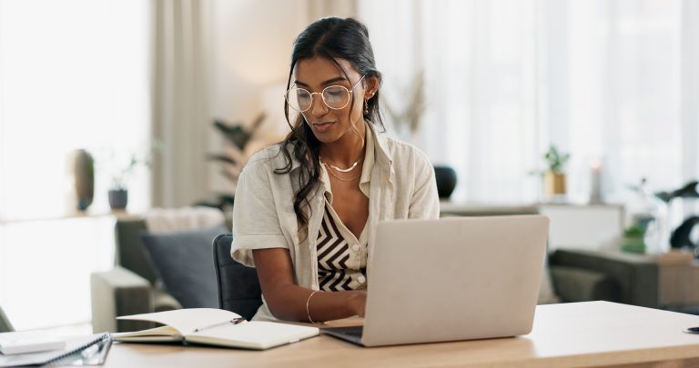 Person writing content on a computer using GEO copywriting best practices for AI search.
