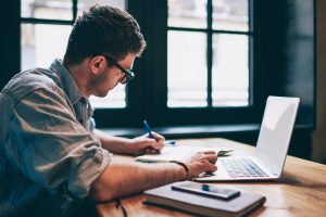 Person working on a computer to optimize existing blog content for generative engine optimization.